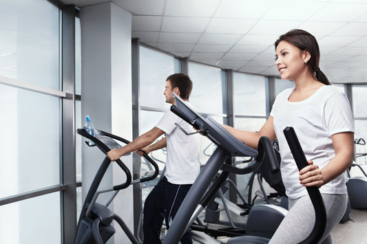 Two people exercising on treadmills in a gym